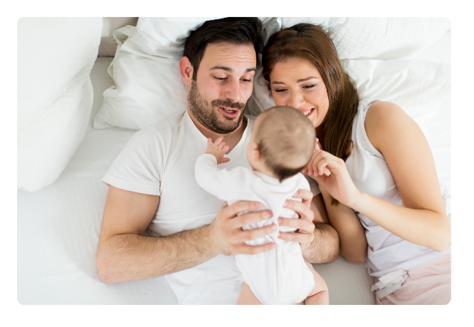 Familia en cama con bebe en brazos